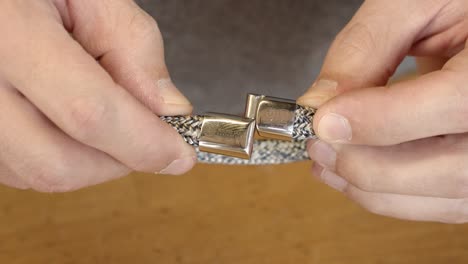 Craftsman-checking-freshly-made-bracelet-clasps-by-connecting,-close-up-view