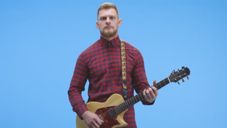 man playing guitar in plaid shirt