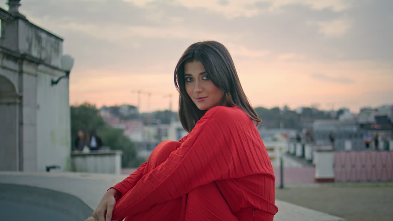 Romantic woman sitting fountain at evening city zoom on. Relaxed woman posing