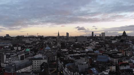 aerial rearward and downward flight over brussels city on cloudy and sunny day, belgium