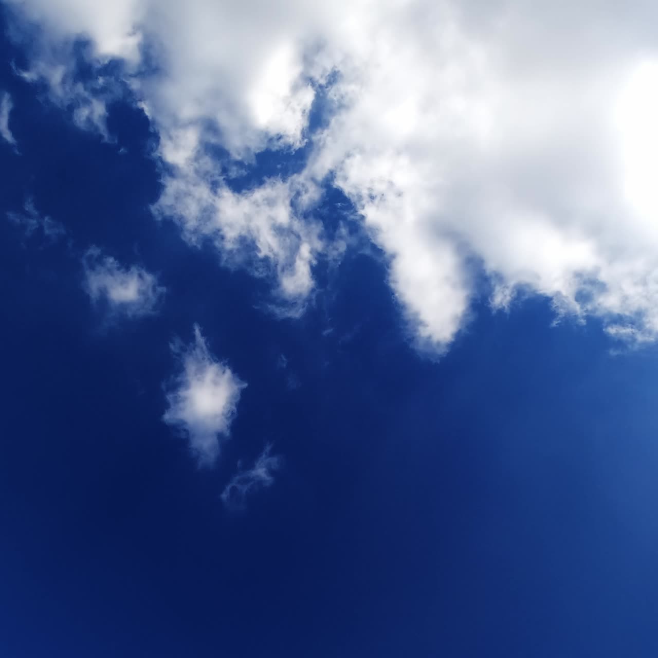 Cielo estivo azzurro brillante con nuvole che si spostano rapidamente. Pesanti nuvole di cotone bianco trasportate dal vento