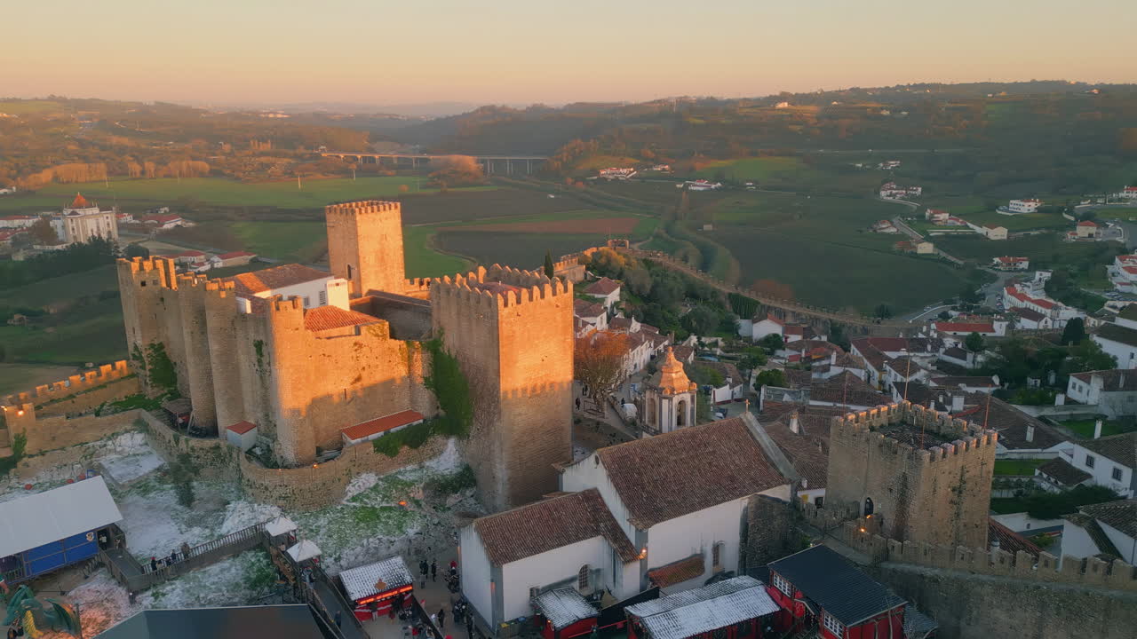 Scenic evening medieval castle placed at village aerial view. Old ancient walls
