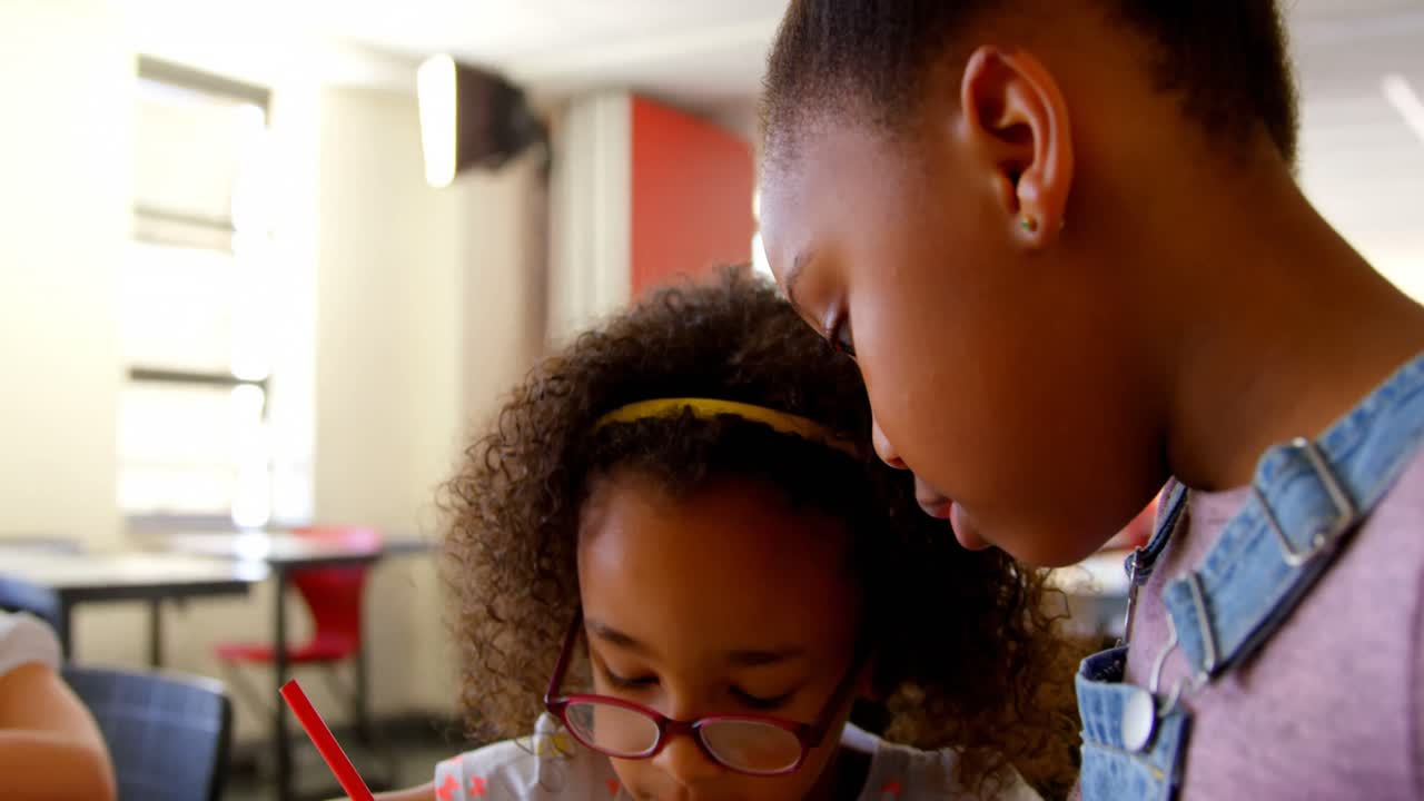 Disabled African American schoolgirl studying at desk in classroom at school 4 4k