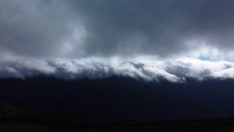 Drone-view-of-Low-dark-Clouds-On-Madeira-Island-Mountains,-Pan-Shot-of-Mysty-Sky