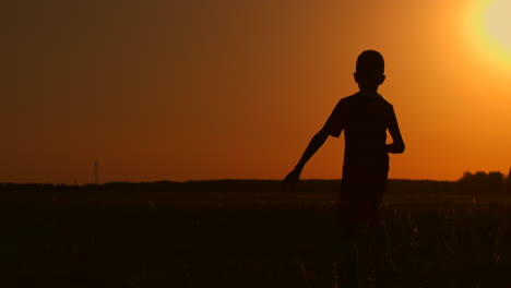 Ein-Junger-Fußballspieler-Trainiert-Mit-Einem-Ball,-Der-An-Seinem-Bein-Hängt,-Bei-Sonnenuntergang-In-Zeitlupe-Während-Der-Goldenen-Stunde-Auf-Dem-Feld-Bis-Zum-Sonnenuntergang.-Training-Von-Der-Dämmerung-Bis-Zum-Morgengrauen.-Konzeptweg-Zum-Erfolg