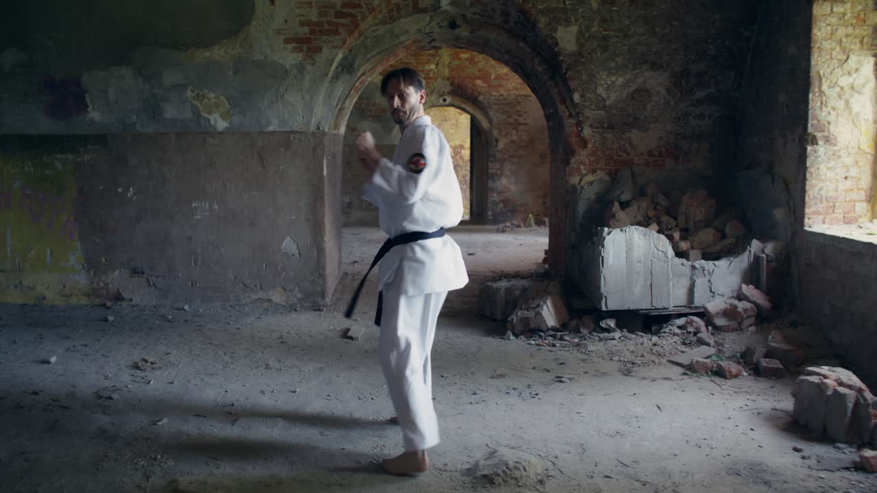 Uomo che pratica karate in un edificio abbandonato