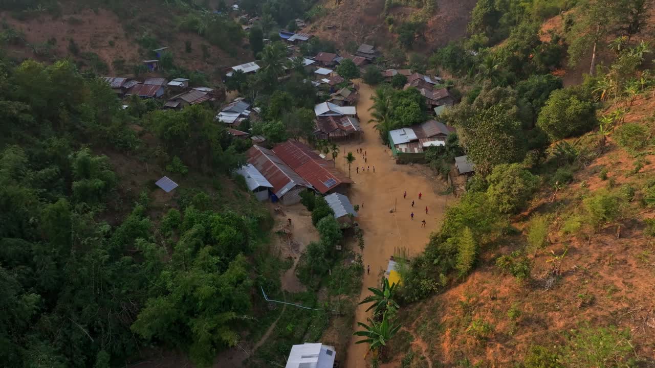 Traditionelle landsbybørn leger i frodige bjergomgivelser, Thailand