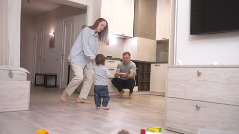 madre ayudando a su bebé a dar sus primeros pasos hacia la cocina