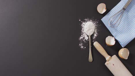 video of baking ingredients and tools lying on black surface with copy space