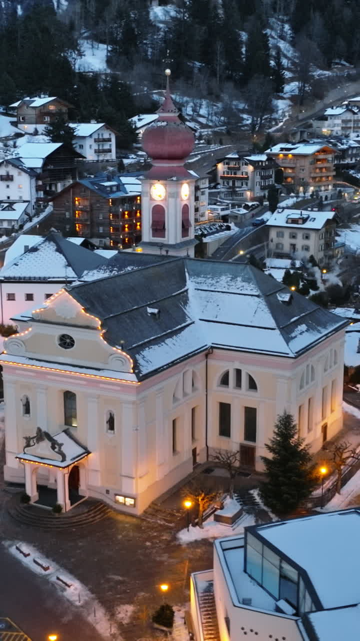 Aerial drone view of the Ortisei town covered in snow at night, within the Dolomites, in northern Italy. Vertical