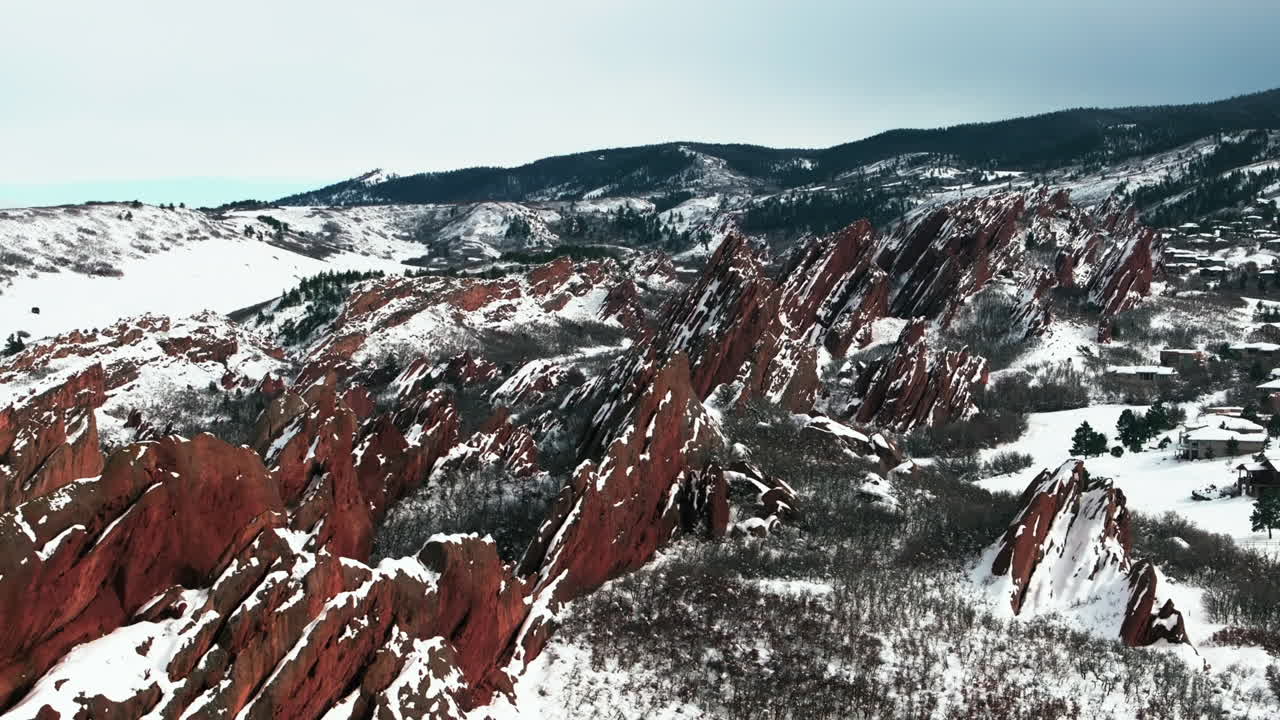 Syvän lumen kevätmyrskyn jälkeinen Roxborogh State Parkin golfkenttä, ilmakuva dronella, Coloradon Front Range, talvinen kevät, syvä puuterilumi, dramaattinen vuoristomaisema, Littleton, Denver, terävät punaiset kalliot, taaksepäin avautuva näkymä.