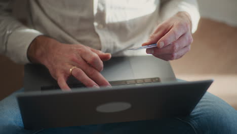 close-up of a man holding a credit card in hand making online payment