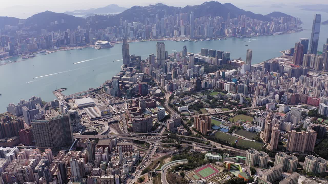 horizonte de hong kong, paso aéreo lento hacia el puerto de victoria, sobre la bahía de kowloon y el área urbana