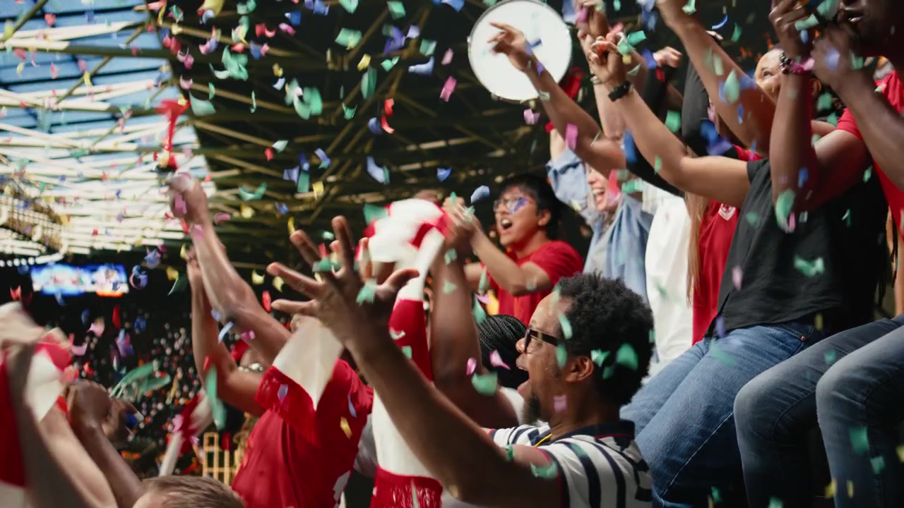 Voetbalsupporters vieren de overwinning met confetti en een juichende menigte