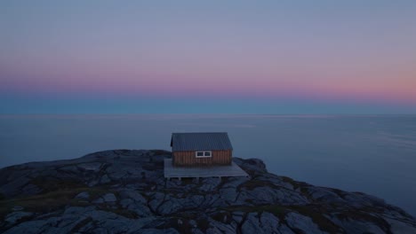 solitary cabin on a clifftop at dawn/dusk
