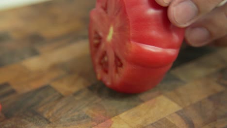 cortando un tomate maduro con un cuchillo japonés afilado