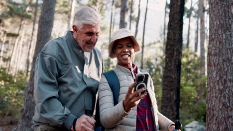 una pareja de ancianos haciendo senderismo y tomando fotos.