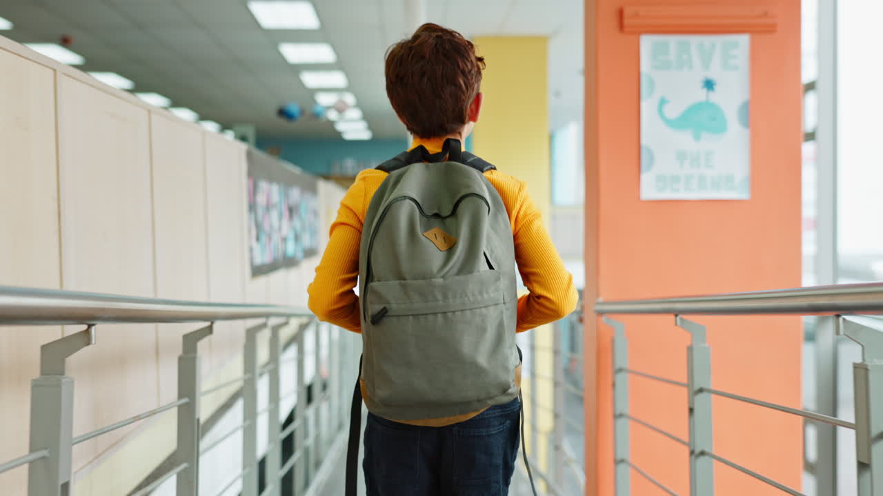 Boy with Backpack Walking in School Corridor
