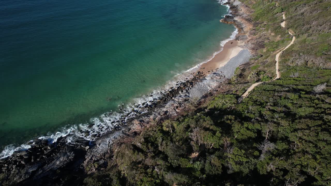 Waves Along Granite Pebbled Shores Of Granite Bay In Noosa National Park, Queensland, Australia. Aerial Topdown Shot