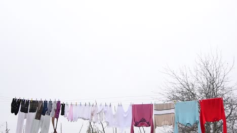 clothes hanging on an outside washing line drying naturally under an overcast sky