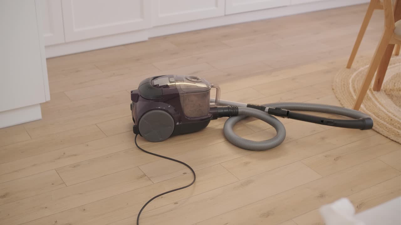 Vacuum Cleaner Running on Light Wooden Floor
