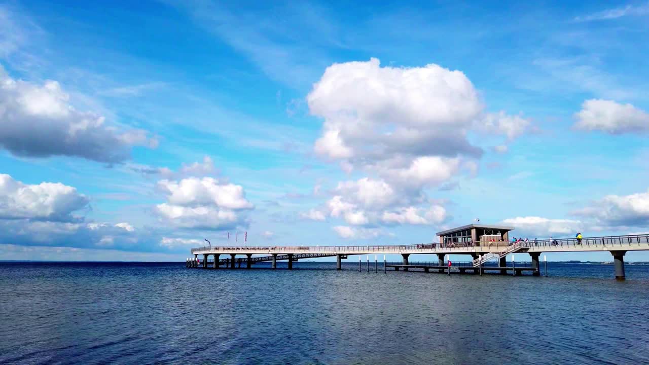 Baltic Sea pier at Haffkrug under blue cloud-dappled skies
