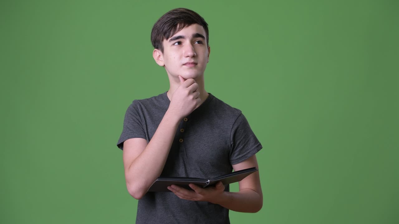 joven y guapo adolescente iraní contra un fondo verde