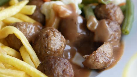 meatballs with gravy, fries and green beans