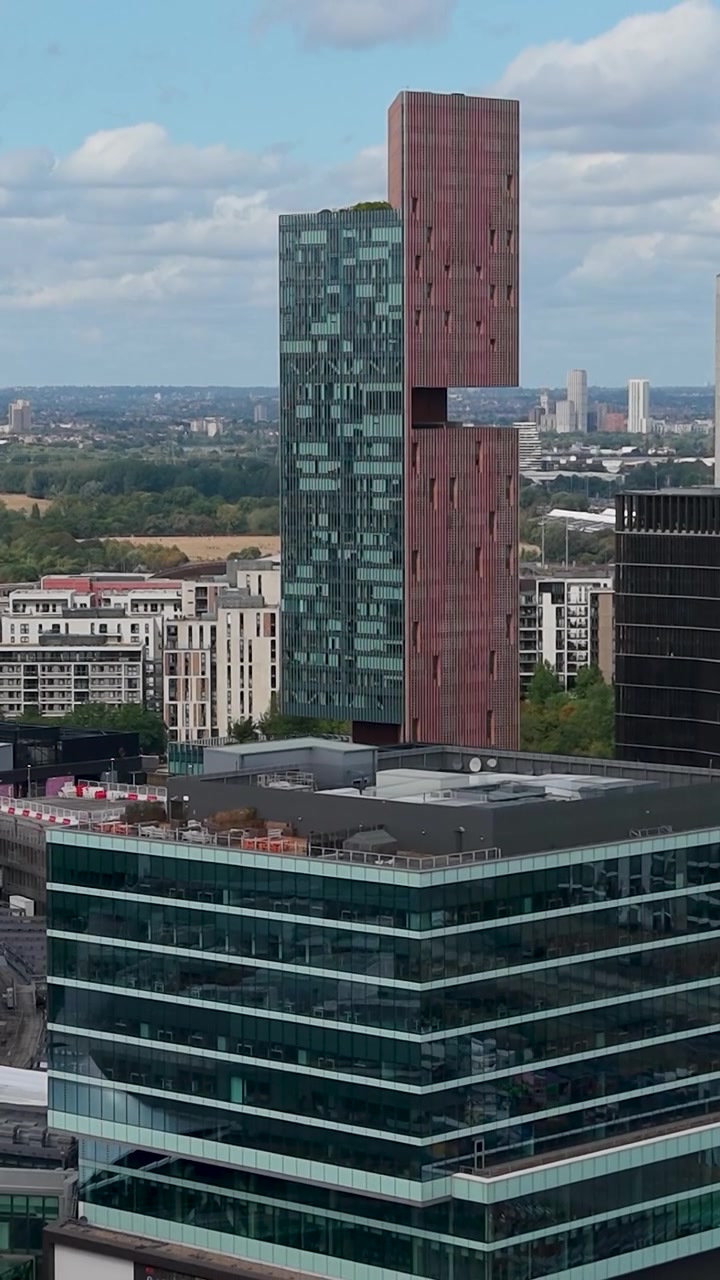 A descida de drone em Stratford Westfield revela o recorte do Manhattan Loft Gardens, telhados de lojas, fachadas, ônibus de Londres e a paisagem urbana circundante do Leste de Londres. Formato vertical