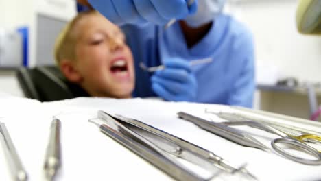 Dentist-examining-a-young-patient-with-tools