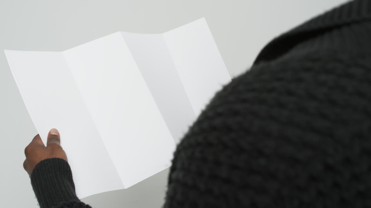 video de las manos de un hombre afroamericano sosteniendo una página en blanco, copia espacio en fondo blanco