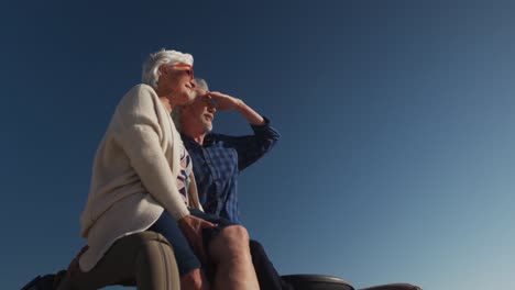 senior couple sitting on a car