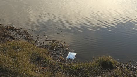 used medical mask in water of lake