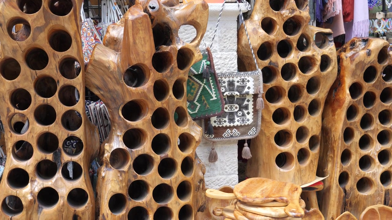 Hand carved wood wine bottle racks embroidered bags and souvenirs at Kruje Old Bazaar Albania