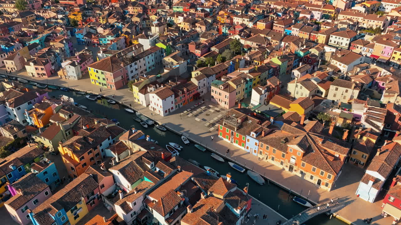 Aerial drone view of boats on the sides of a canal near the colourful houses of Burano Island, Italy