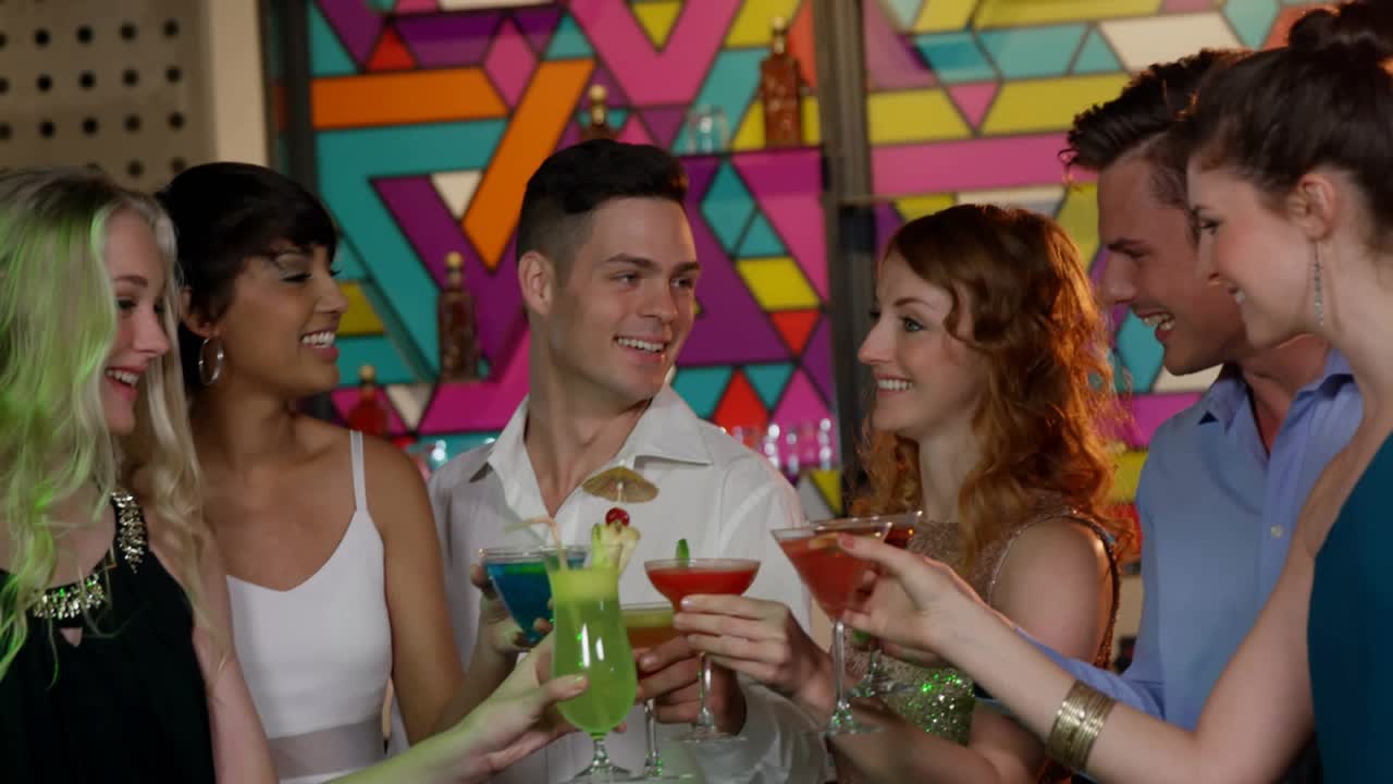 Six friends raising glasses, sparking white bubbles rising and obscuring drinks for nightlife toast