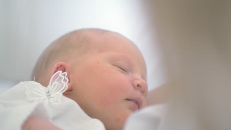 newborn baby girl asleep in her mothers arms