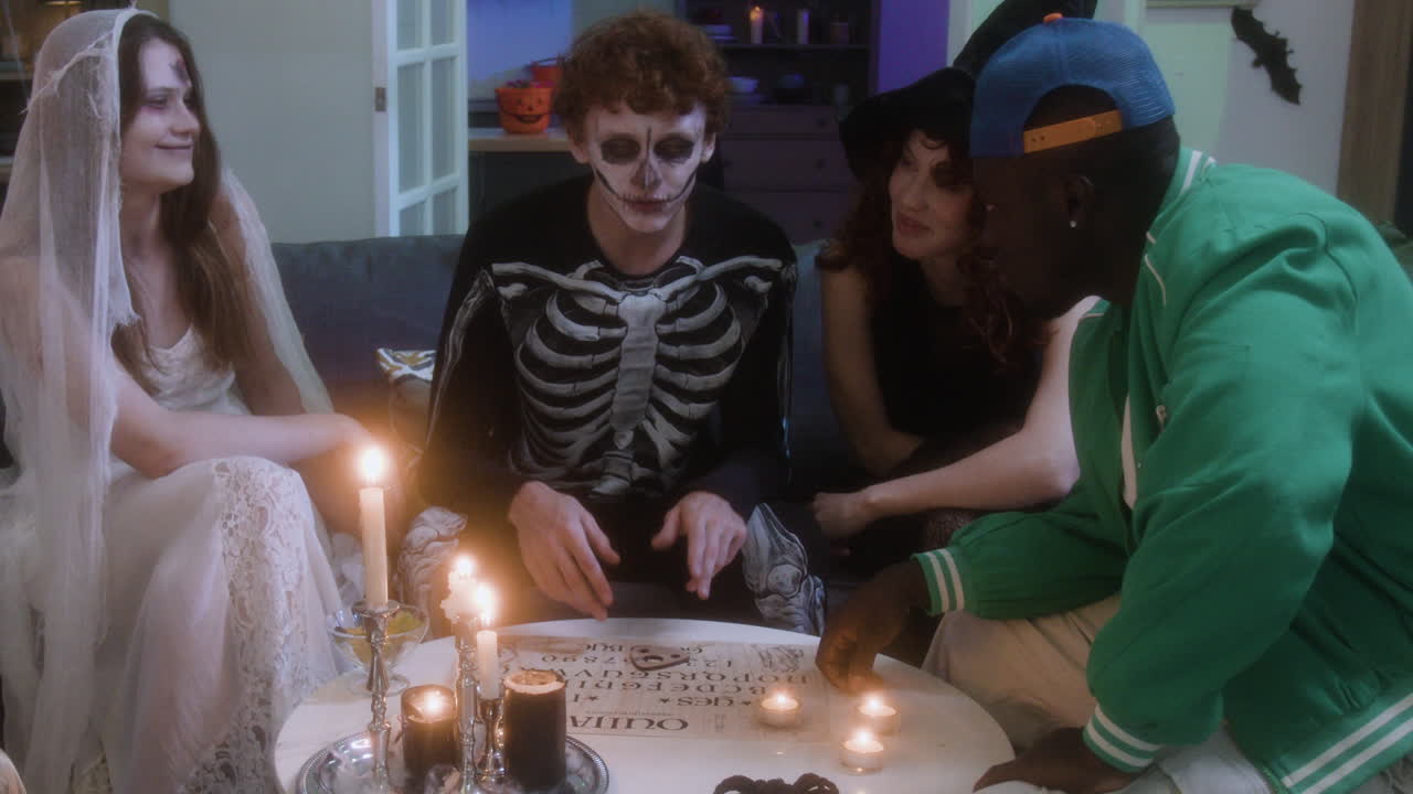 A Group of Friends Playing with an Ouija Board at Halloween