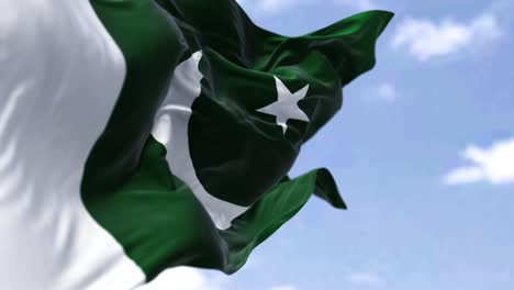 detail of the national flag of pakistan waving in the wind on a clear day.