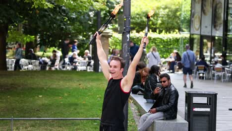 performer juggling fire torches in public park