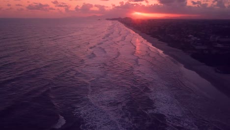 tilting aerial shot of waves in the beach of itanhaem in brazil