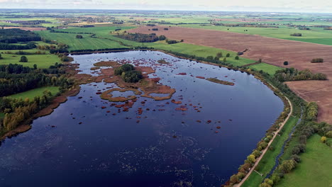 Luftaufnahme-Des-Idyllischen-Landschaftssees-Und-Der-Einfachen-Landwirtschaftlichen-Unholde-Drohnenaufnahme