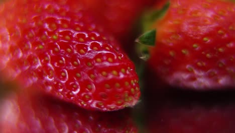 macro detailed video of a pile of strawberries, red raw strawberry, green leaf, tiny seeds, on a rotating stand, smooth movement, slow motion 120fps