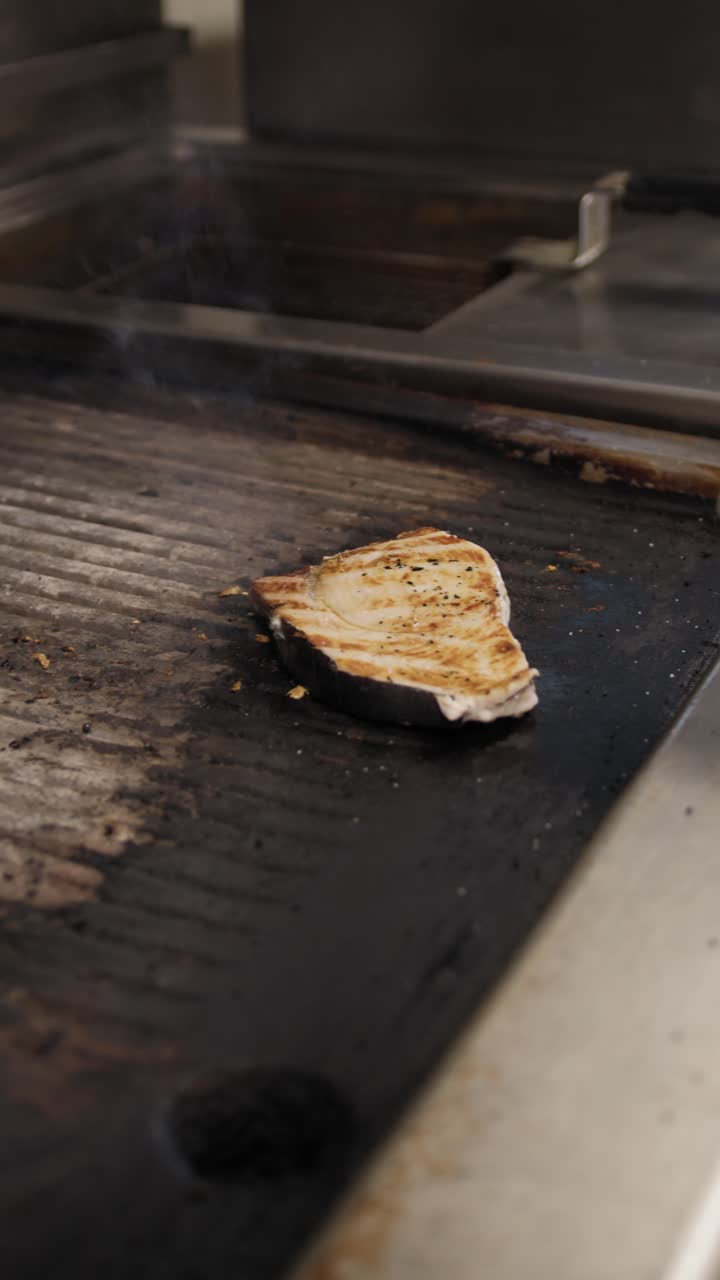 Chef Grabbing The Grilled Swordfish And Putting It In The Dish