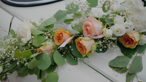 Elegantes-Blumenarrangement-Mit-Pfirsichfarbenen-Und-Weißen-Rosen-Auf-Einem-Auto,-Ideal-Für-Hochzeiten