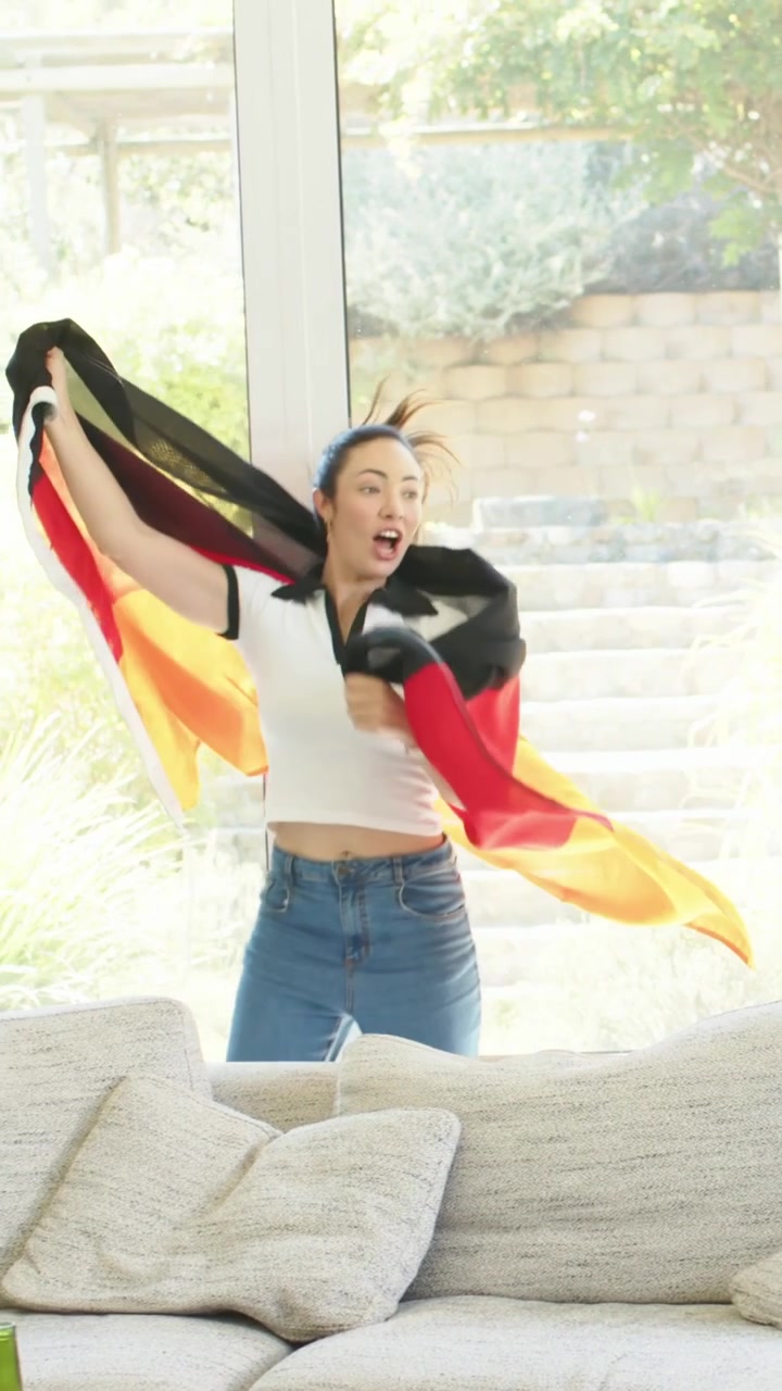 Group dancing near sofa celebrating, woman entering spinning flag, motion trails aiding marketing