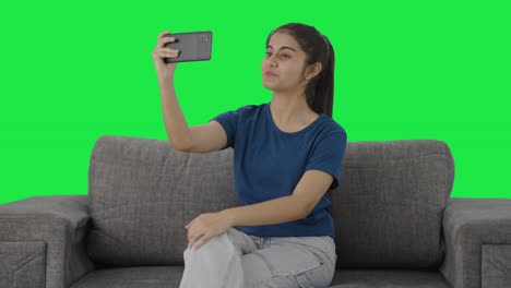 Happy-Indian-teenage-girl-shooting-a-vlog-for-social-media-Green-screen