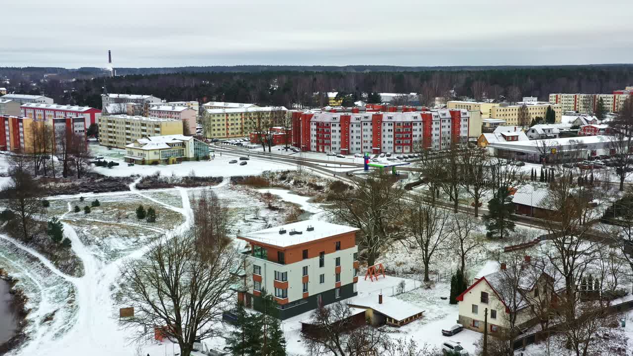 Kold vinterdag med bylandskab, lejlighedsbygninger, huse og hvide parkstier