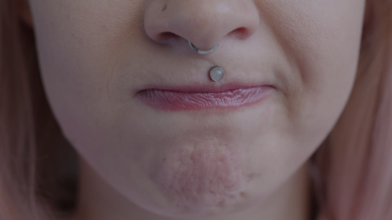 Close-up of woman with lip and nose piercings