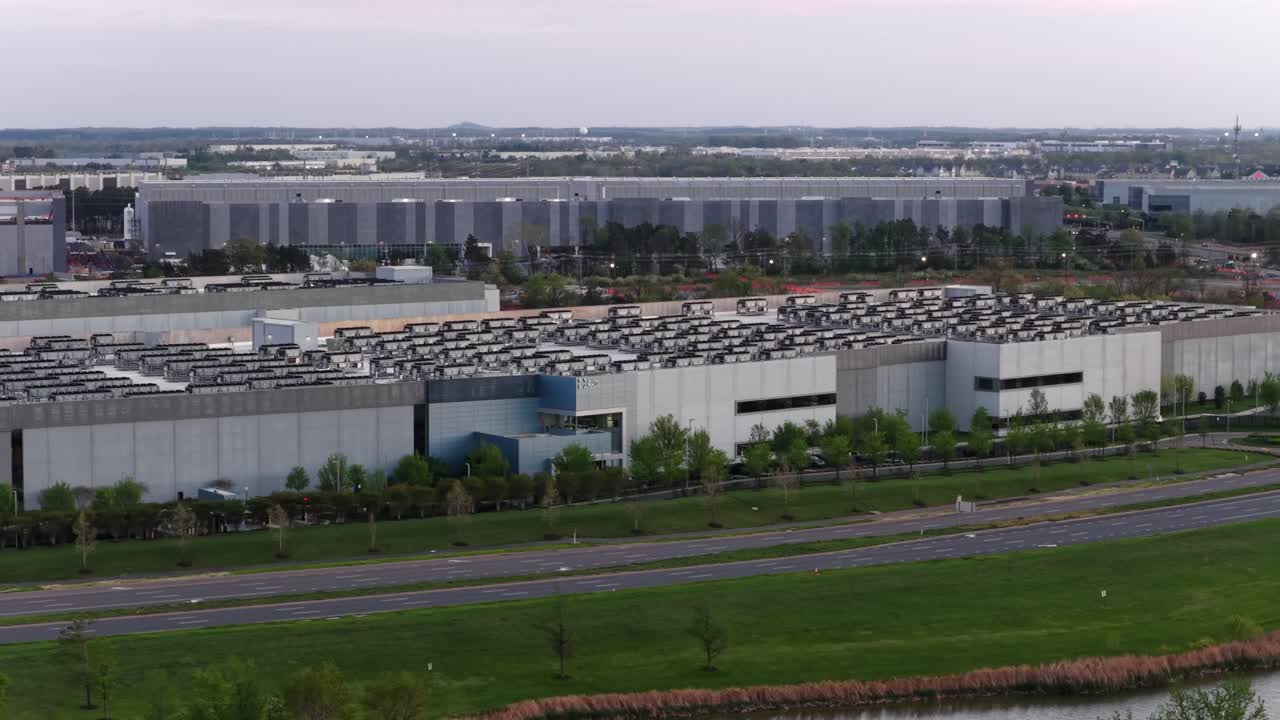 Veduta aerea panoramica di grandi edifici di data center ad Ashburn, Virginia, USA, che mostra moderne strutture server, sistemi sul tetto e infrastrutture stradali vicine in un importante polo tecnologico. Panoramica